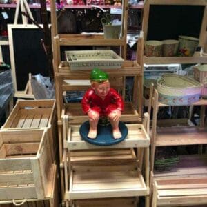 A captivating dapitan-inspired statue of a squatting man in red sits gracefully on the 4 Layer Wood Stand, adding a unique touch to your home decor.