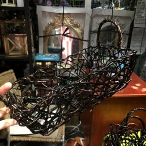 A hand holds a Black Container - Small in a Dapitan home store, surrounded by various items on shelves in the background.