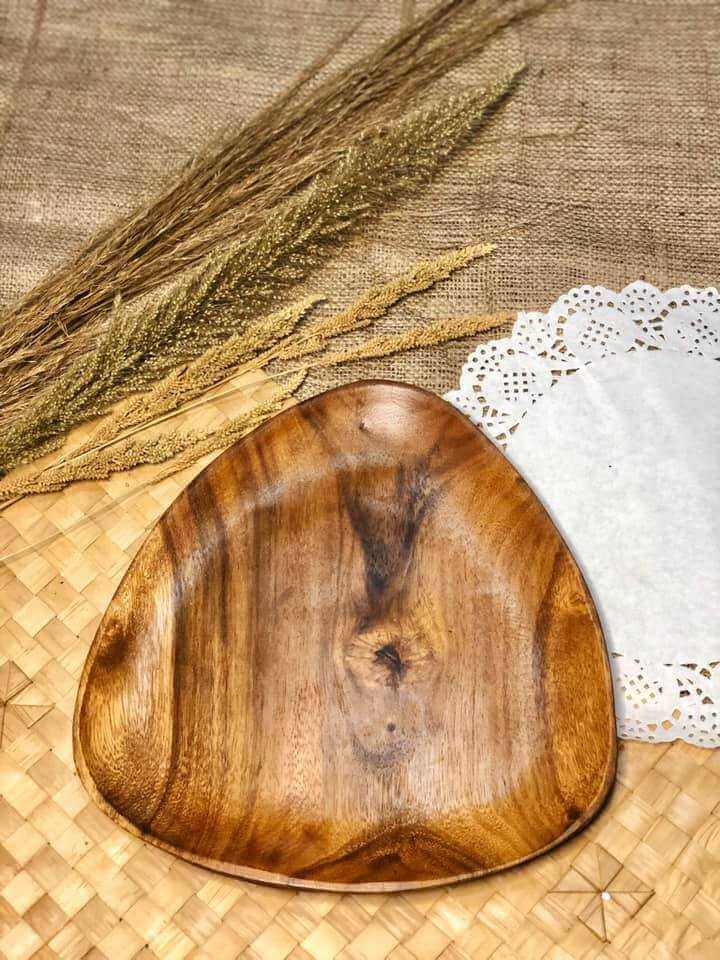 A small wooden round mug/glass coaster rests elegantly on a woven mat, complemented by dried grasses and a lace doily, creating a charming home decor piece reminiscent of Dapitan craftsmanship.