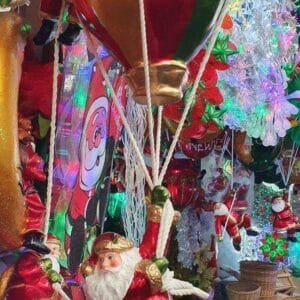 The "Santa in Hot Air Balloon" figurine brings charm to your Dapitan-inspired home decor with its festive design of Santa soaring in a red and green hot air balloon.