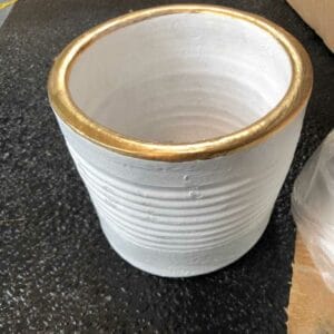 A White Gold Pot (6.3") sits elegantly on a textured black surface, enhancing your home with a touch of Dapitan-inspired decor.
