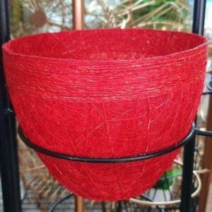 A charming red Big Planter, perfect for any home, elegantly rests on a sleek black metal stand.