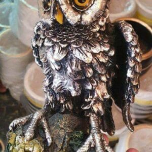 A person holds a detailed Owl Figurine with large eyes and textured feathers, making it a perfect whimsical addition to any home decor. This exquisite piece captures the unique charm typical of Dapitan's artisanal markets.