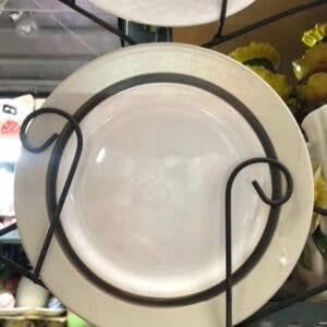 Glossy Round Ceramic Plate with a dark rim on display in a store setting; it's an ideal addition for adding a touch of elegance to your home's decor. Set upon a sleek metal stand, this piece captures the essence of Dapitan craftsmanship and style.