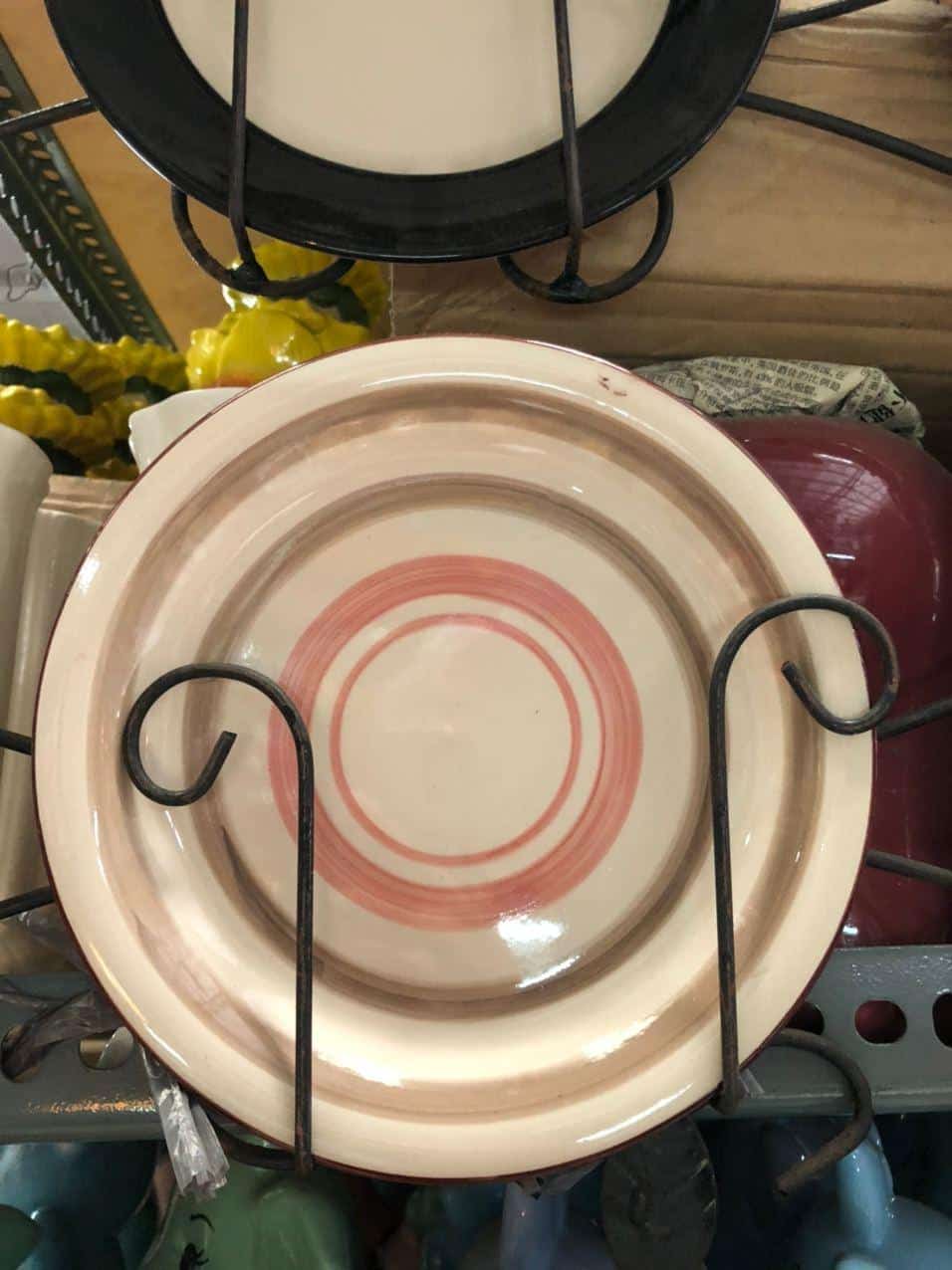 Glossy Round Ceramic Plates featuring concentric red rings, ideal for dapitan-inspired decor, elegantly displayed on a metal stand to enhance your home's aesthetic.