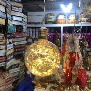 A decorative shop display showcasing a Hanging Bulb light and an array of home decor items and signs that capture the vibrant charm reminiscent of Dapitan.