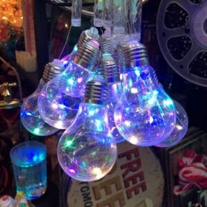 A vibrant string of Multi-colored Bulb Lights brightens the cluttered backdrop, adding a touch of Dapitan's charm to your home decor.